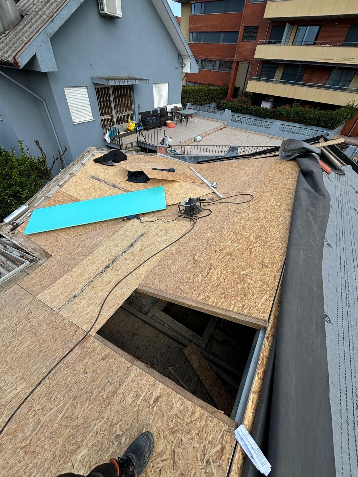 Uma pessoa está deitada no telhado de um prédio.