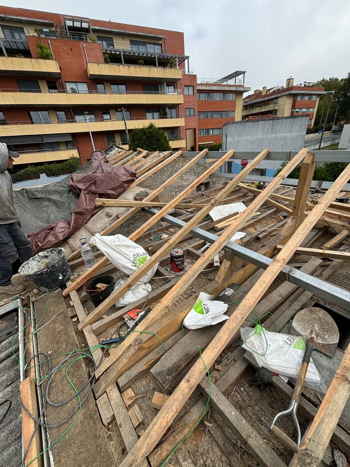 Um homem está trabalhando no telhado de um prédio.