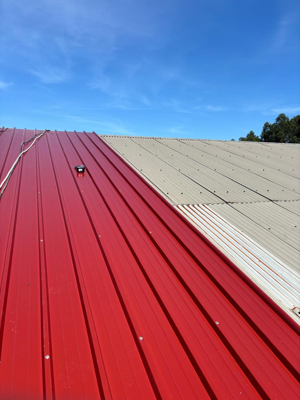 Um telhado de metal vermelho com um céu azul ao fundo