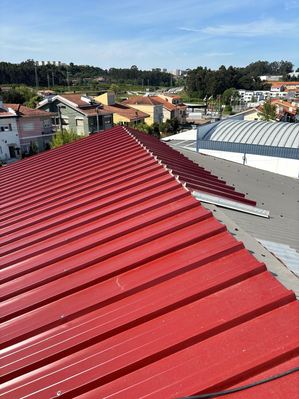 Um telhado vermelho com vista para uma cidade ao fundo