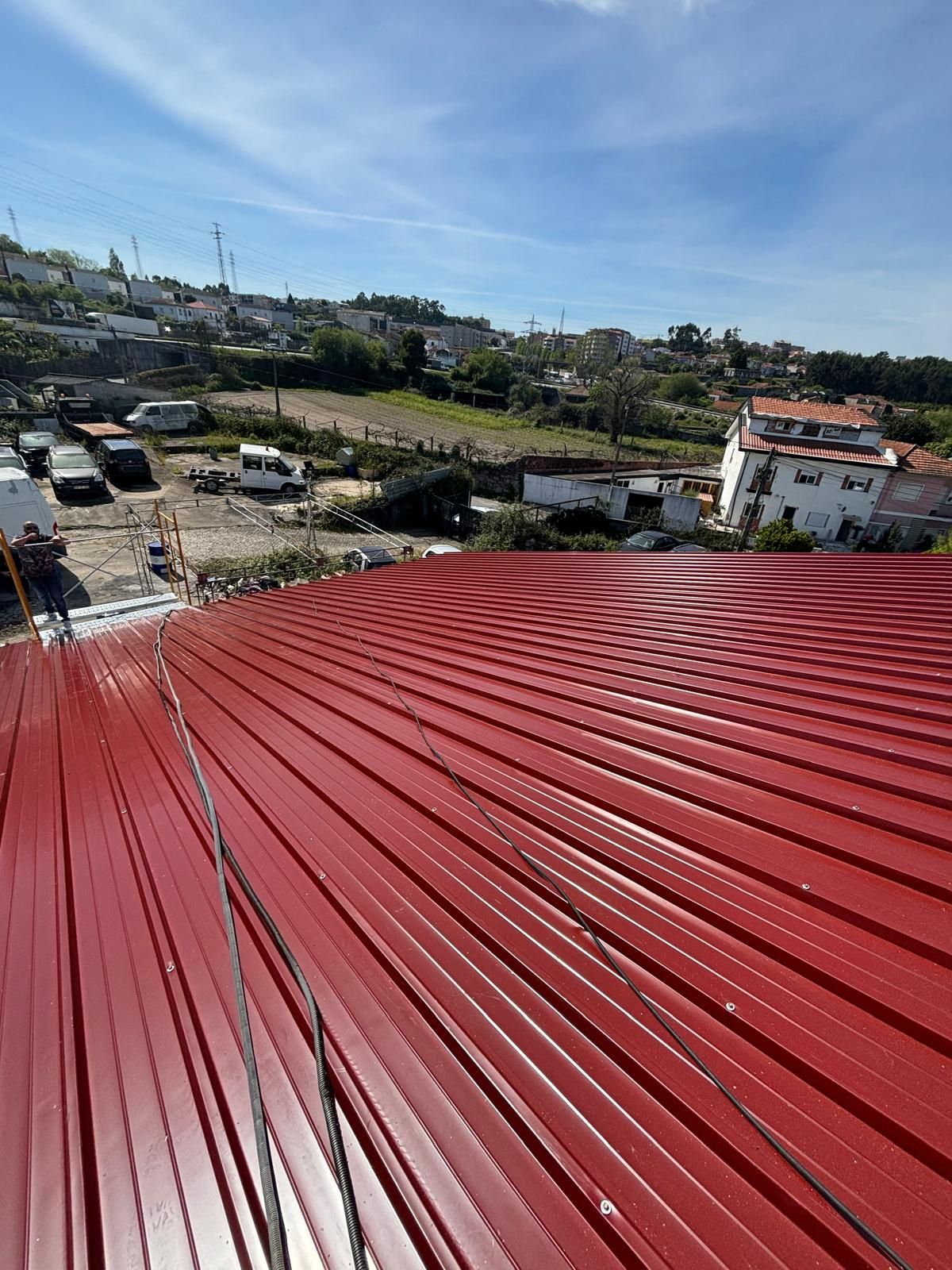 Um telhado vermelho com vista para uma cidade ao fundo.