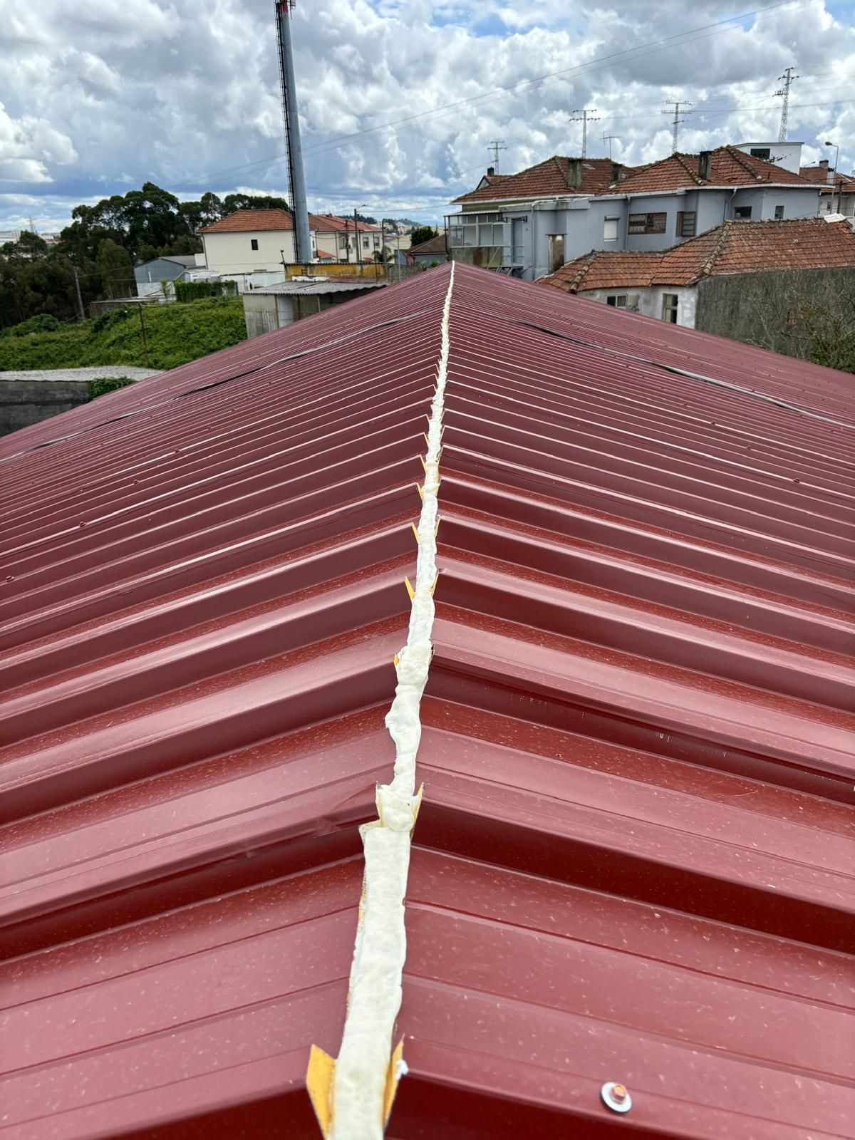 Um telhado em painel sandwich 5 ondas 30mm com uma faixa branca de espuma.