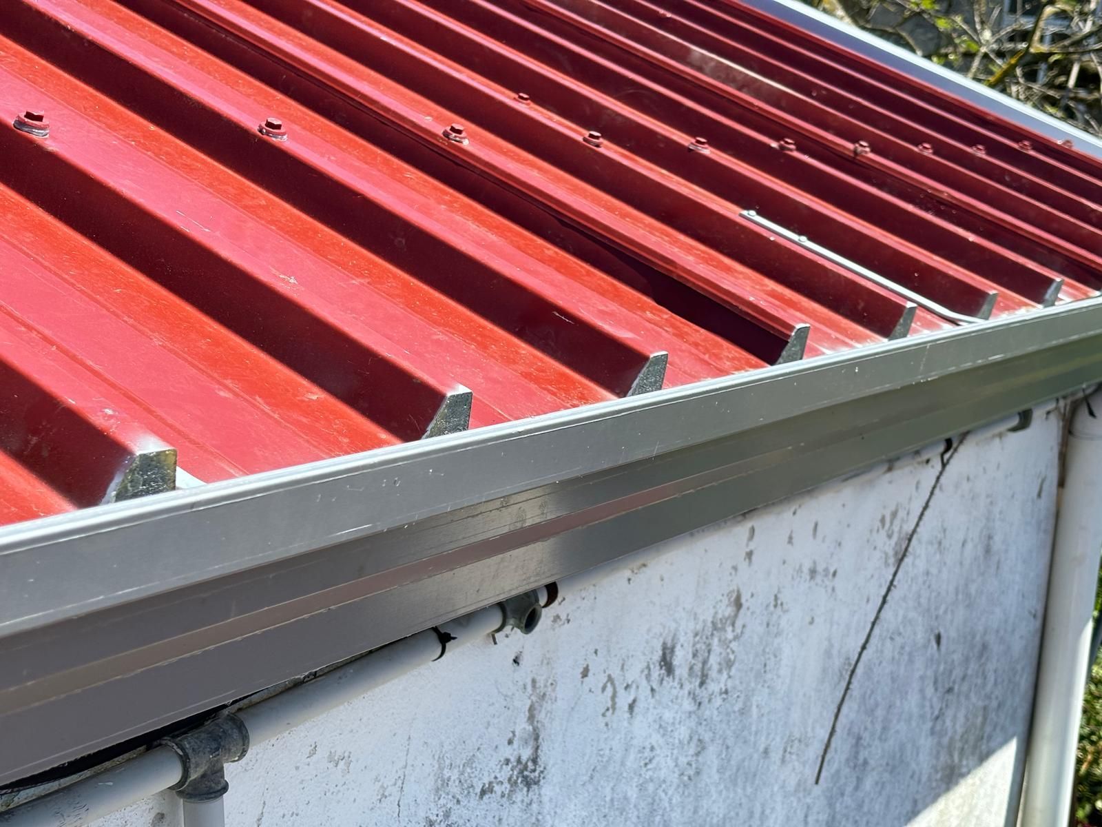 Um telhado vermelho com uma calha na lateral