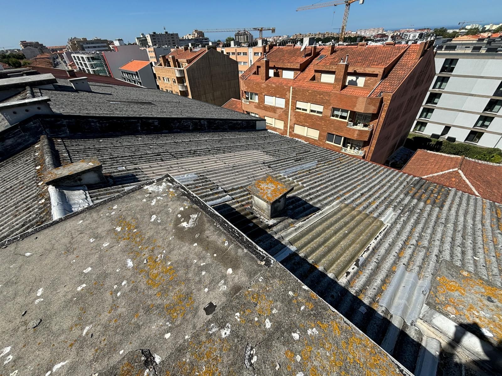 O telhado de um prédio em fibrocimento amianto com uma chaminé