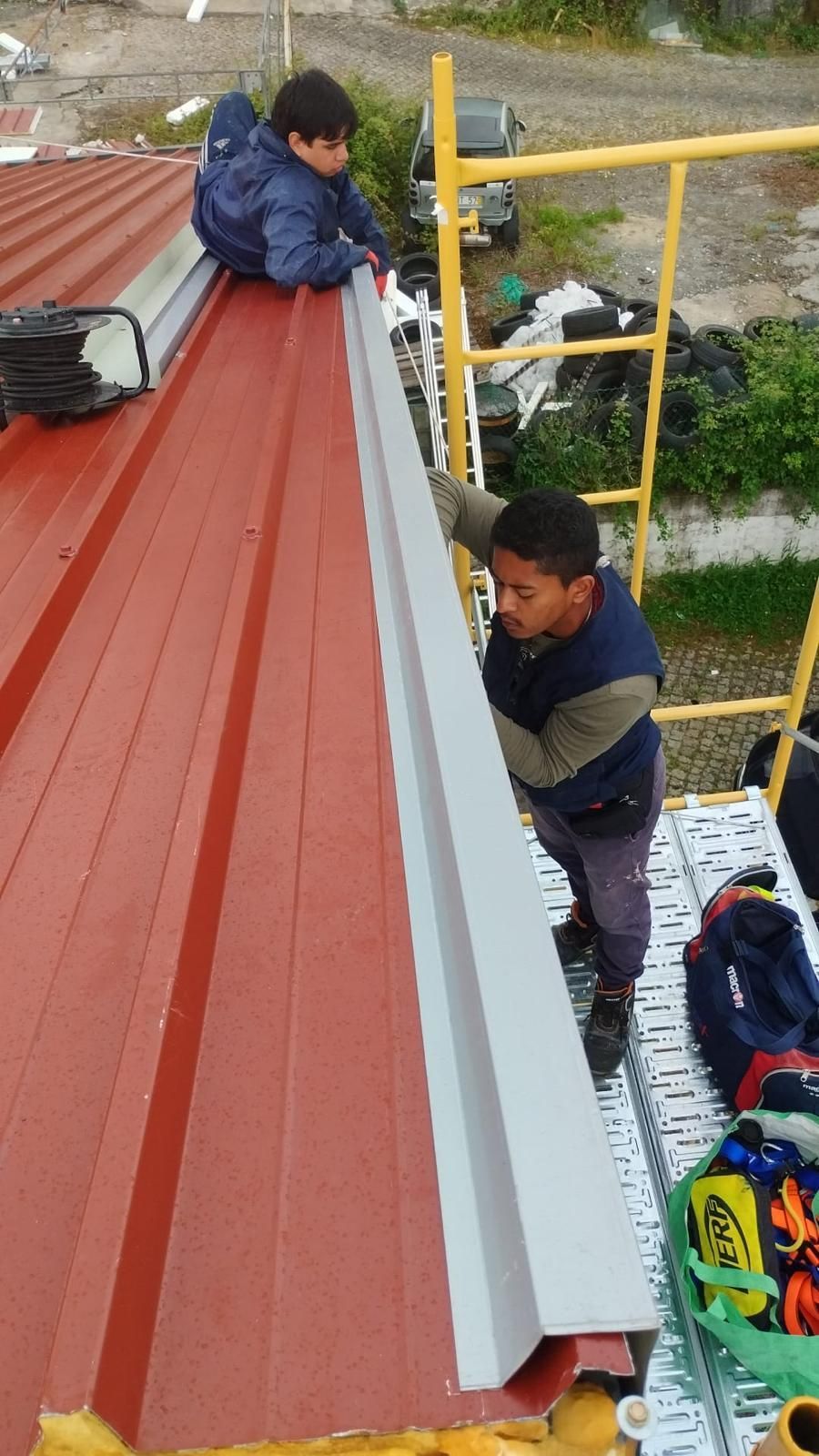 Dois homens estão trabalhando em um telhado em painel sandwich 5 ondas 30mm.