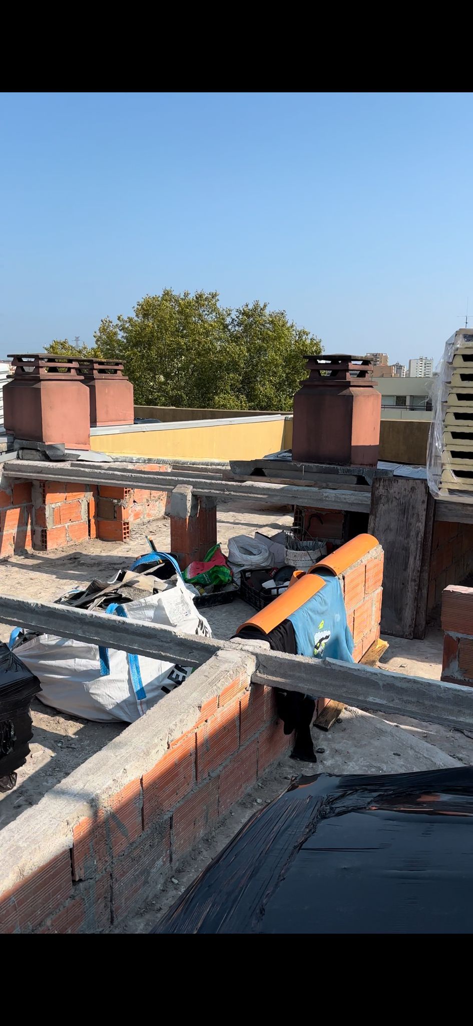 Um telhado com muitas chaminés e um céu azul ao fundo.