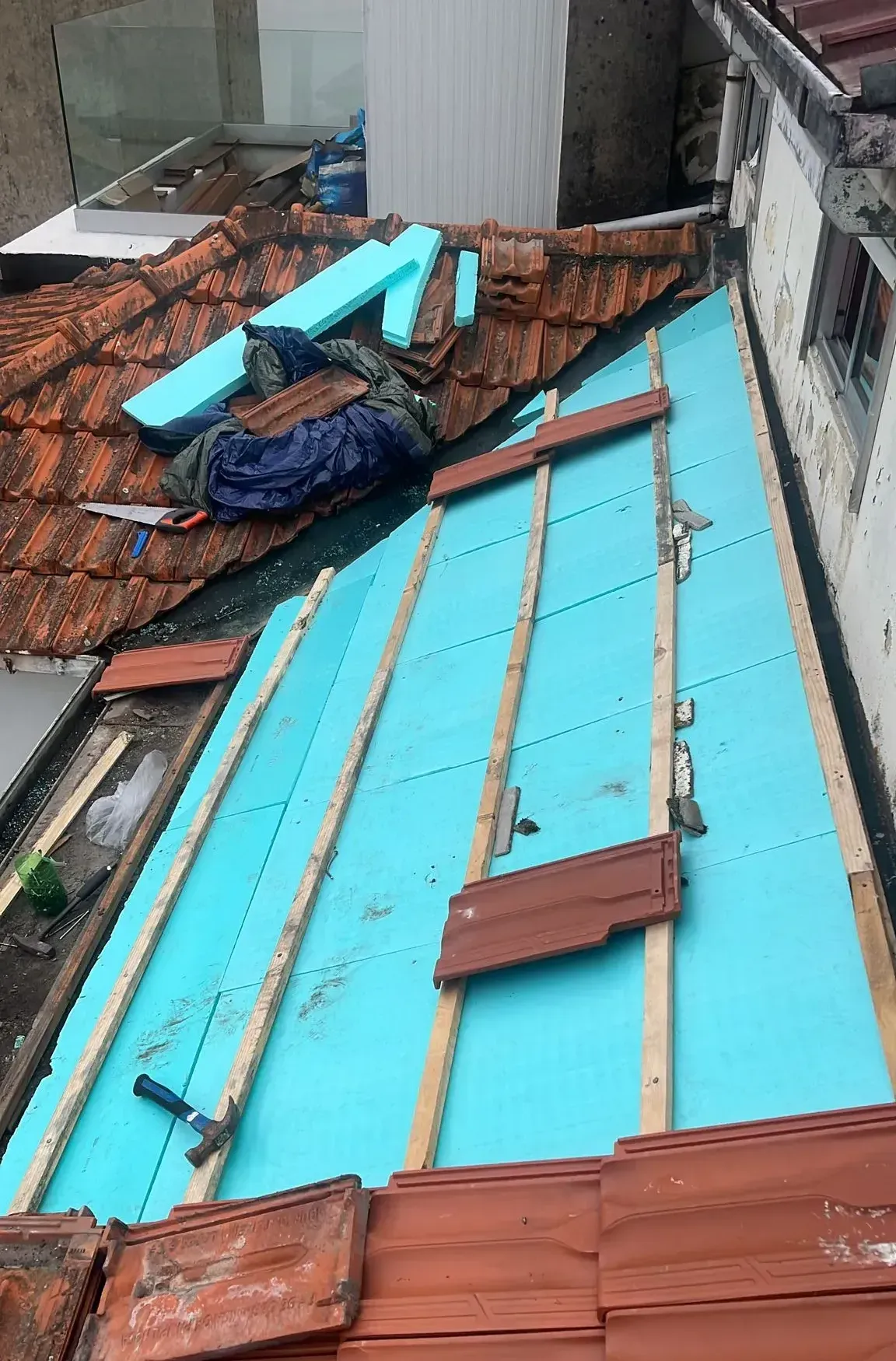 Um telhado com muitas telhas e espuma azul