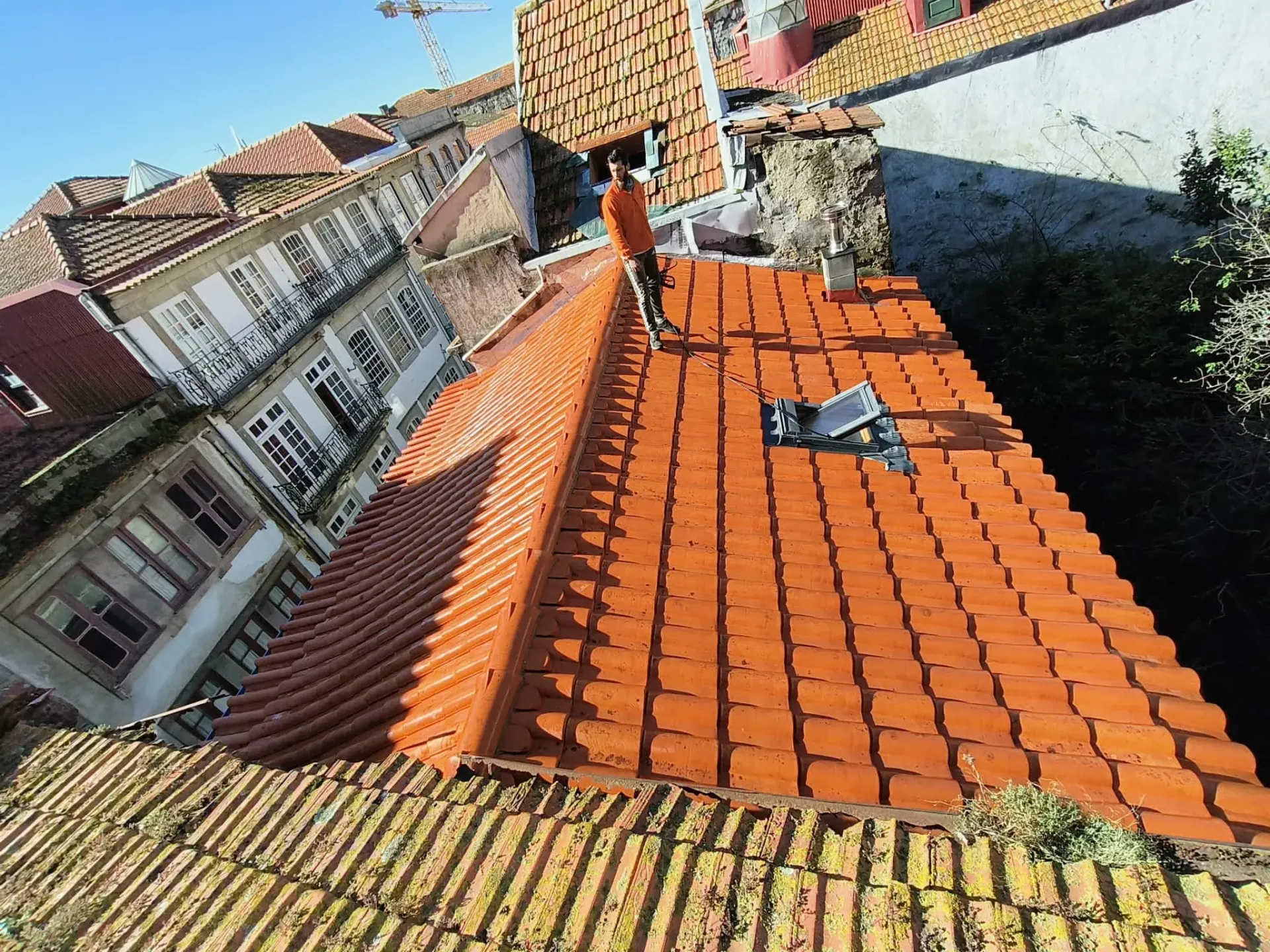 Um telhado com muitas telhas e um prédio ao fundo.