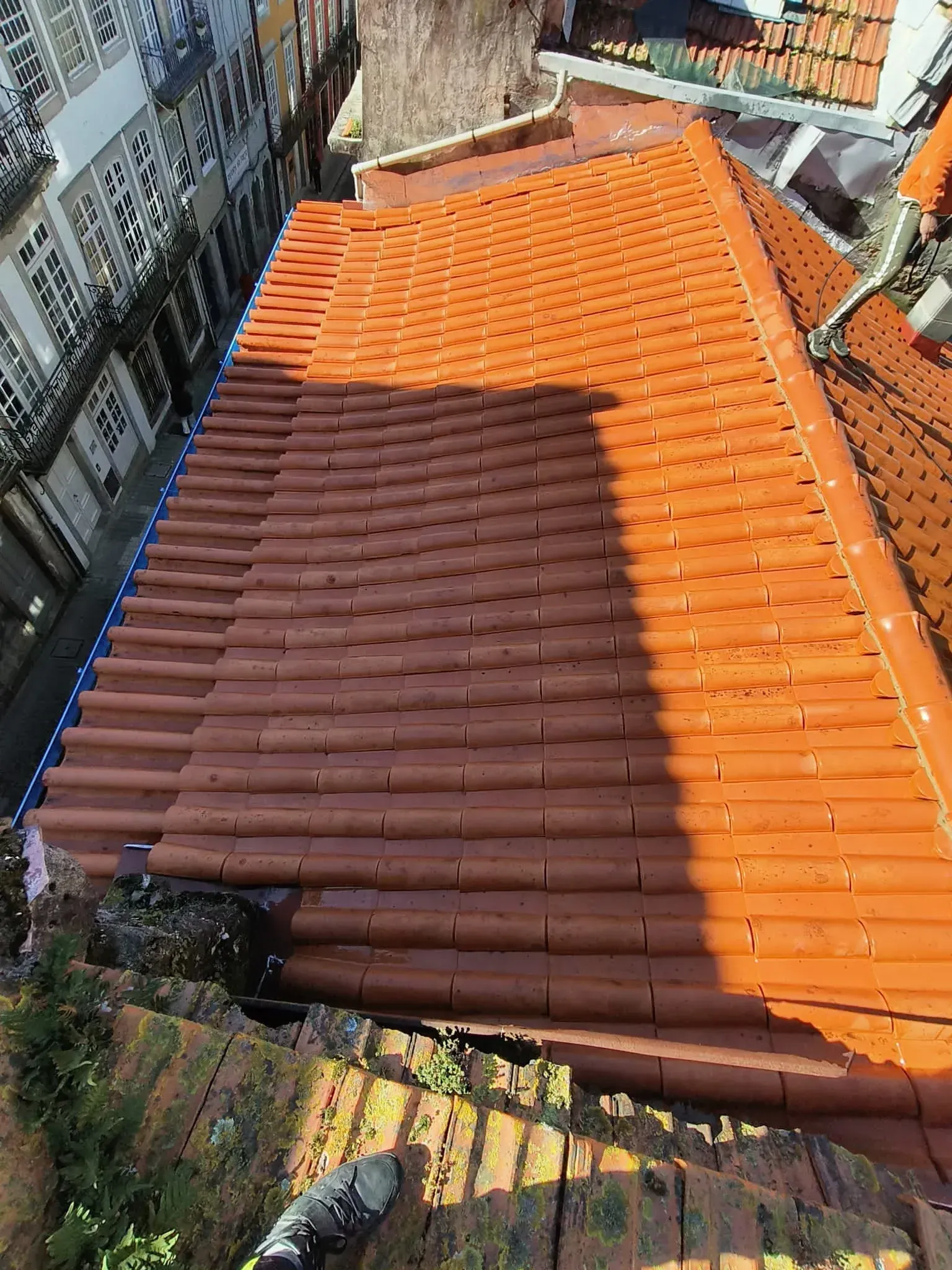 Uma vista aérea de um telhado com telhas vermelhas e uma chaminé.