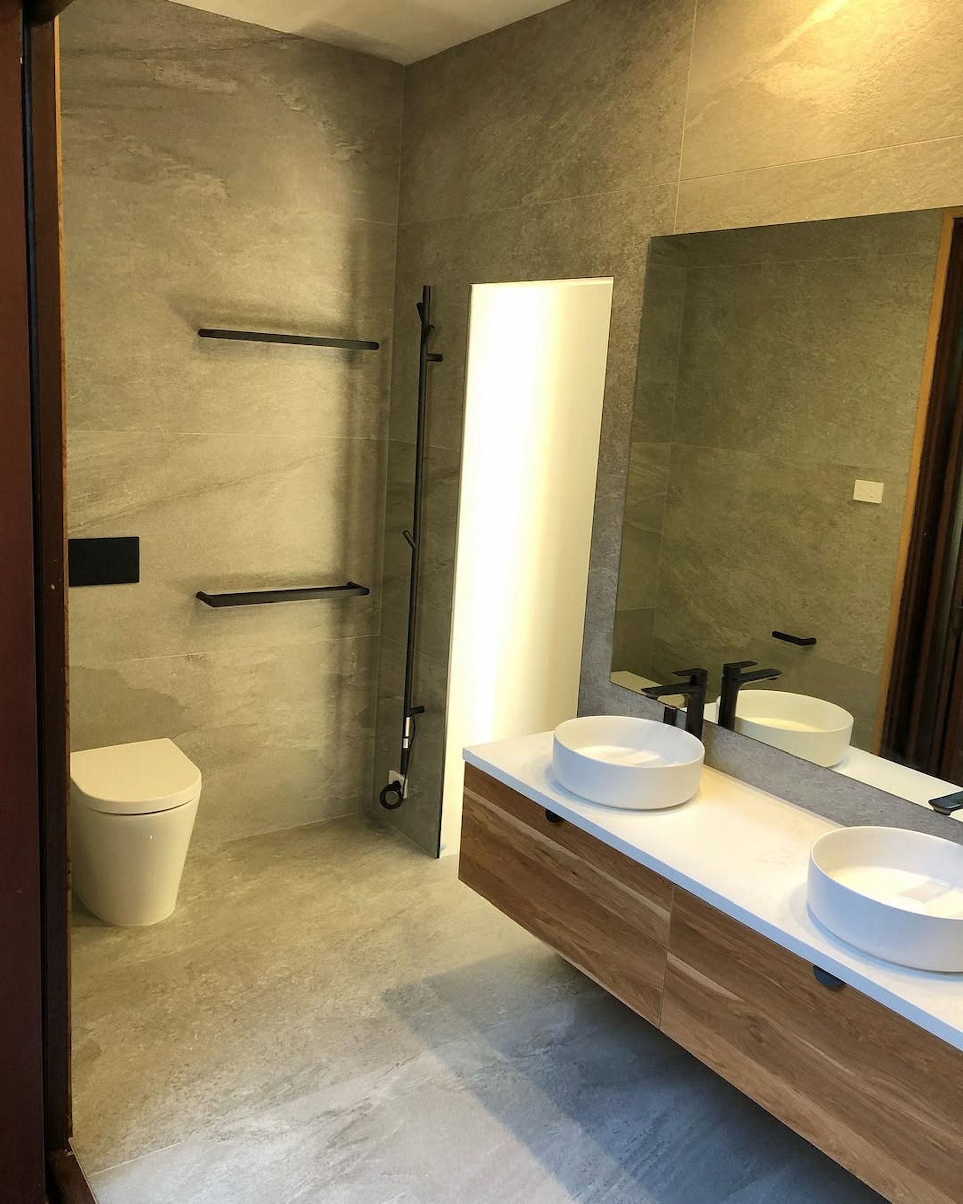 A bathroom with two sinks , a toilet and a large mirror — Canberra Bathroom Solutions in Ngunnawal, ACT