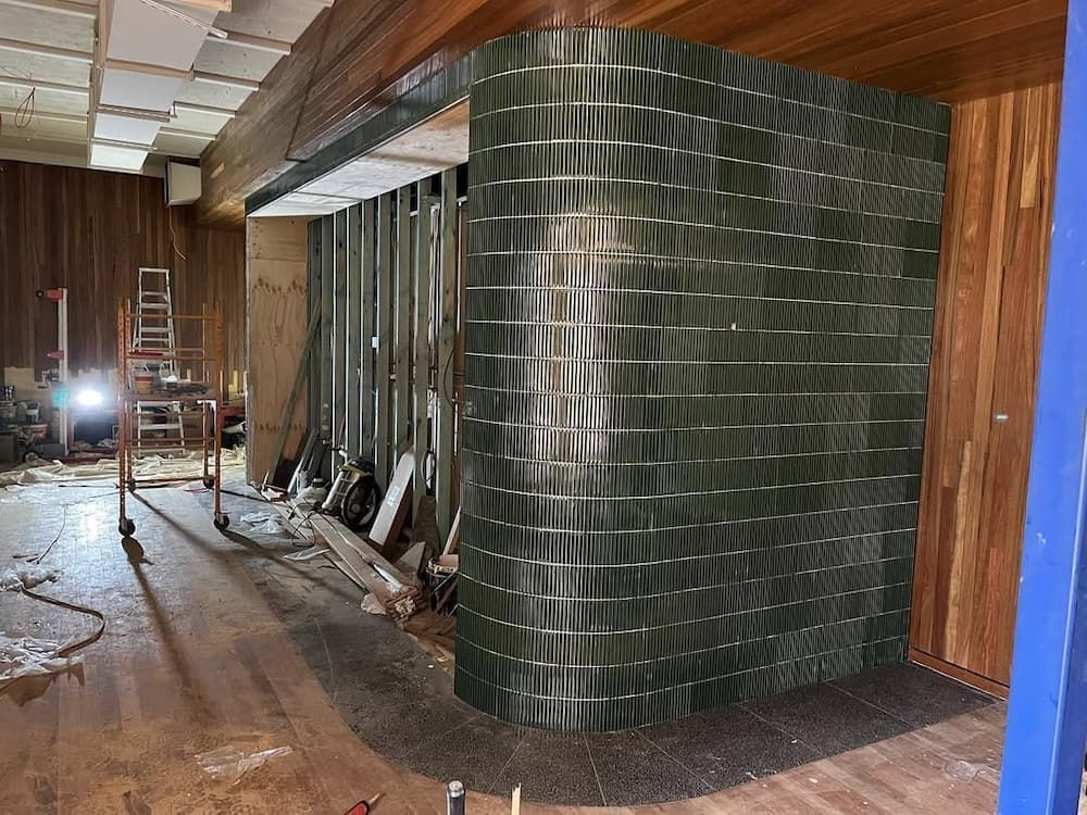 A Room With a Green Tile Wall and Wooden Walls — Canberra Bathroom Solutions in Queanbeyan, NSW