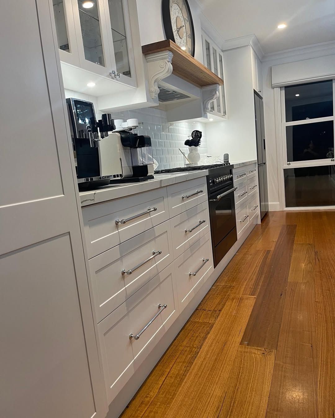 A Kitchen With White Cabinets and Wooden Floors and a Clock on the Wall — Canberra Bathroom Solutions in Belconnen, ACT