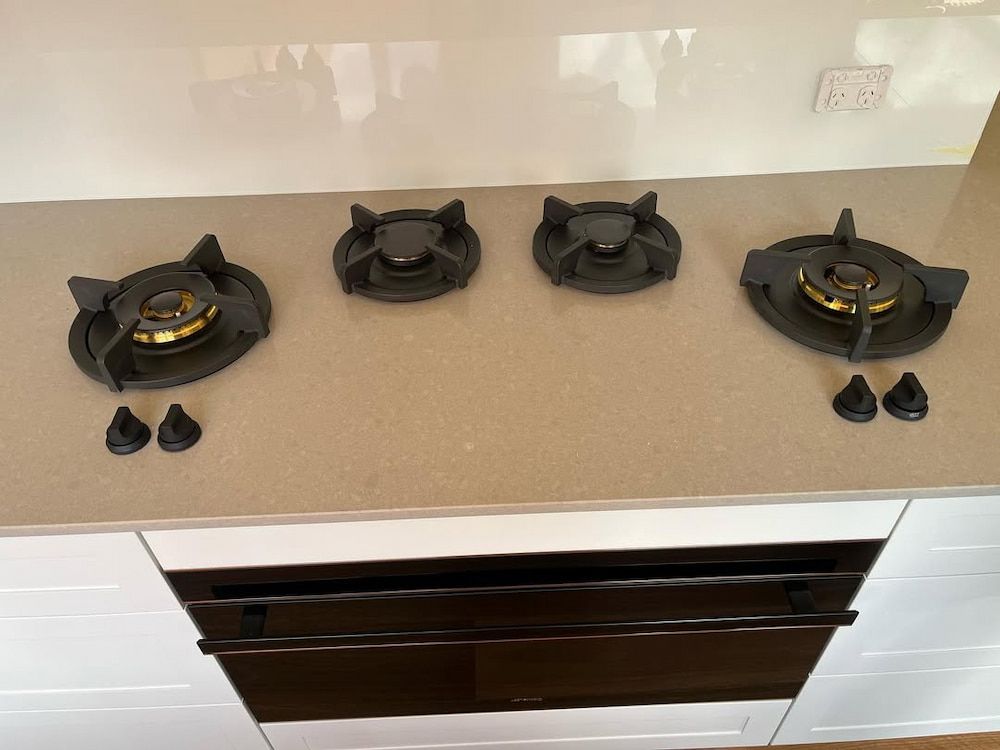 A Kitchen With Four Gas Burners and a Black Oven — Canberra Bathroom Solutions in Ngunnawal, ACT