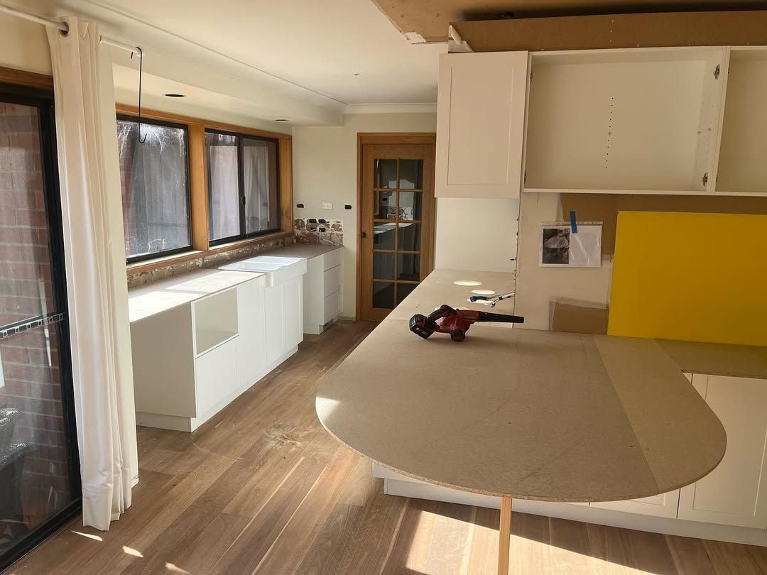 A Kitchen With a Table and a Yellow Wall — Canberra Bathroom Solutions in Belconnen, ACT