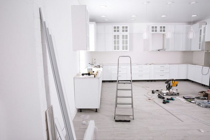 A kitchen is being remodeled with white cabinets and a ladder — Canberra Bathroom Solutions in Ngunnawal, ACT