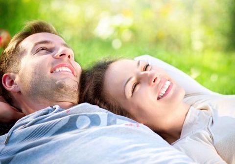 a couple lying on the ground and smiling confidently