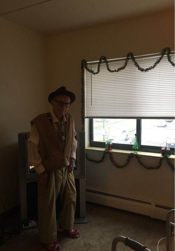 elderly resident hanging Christmas decorations around window