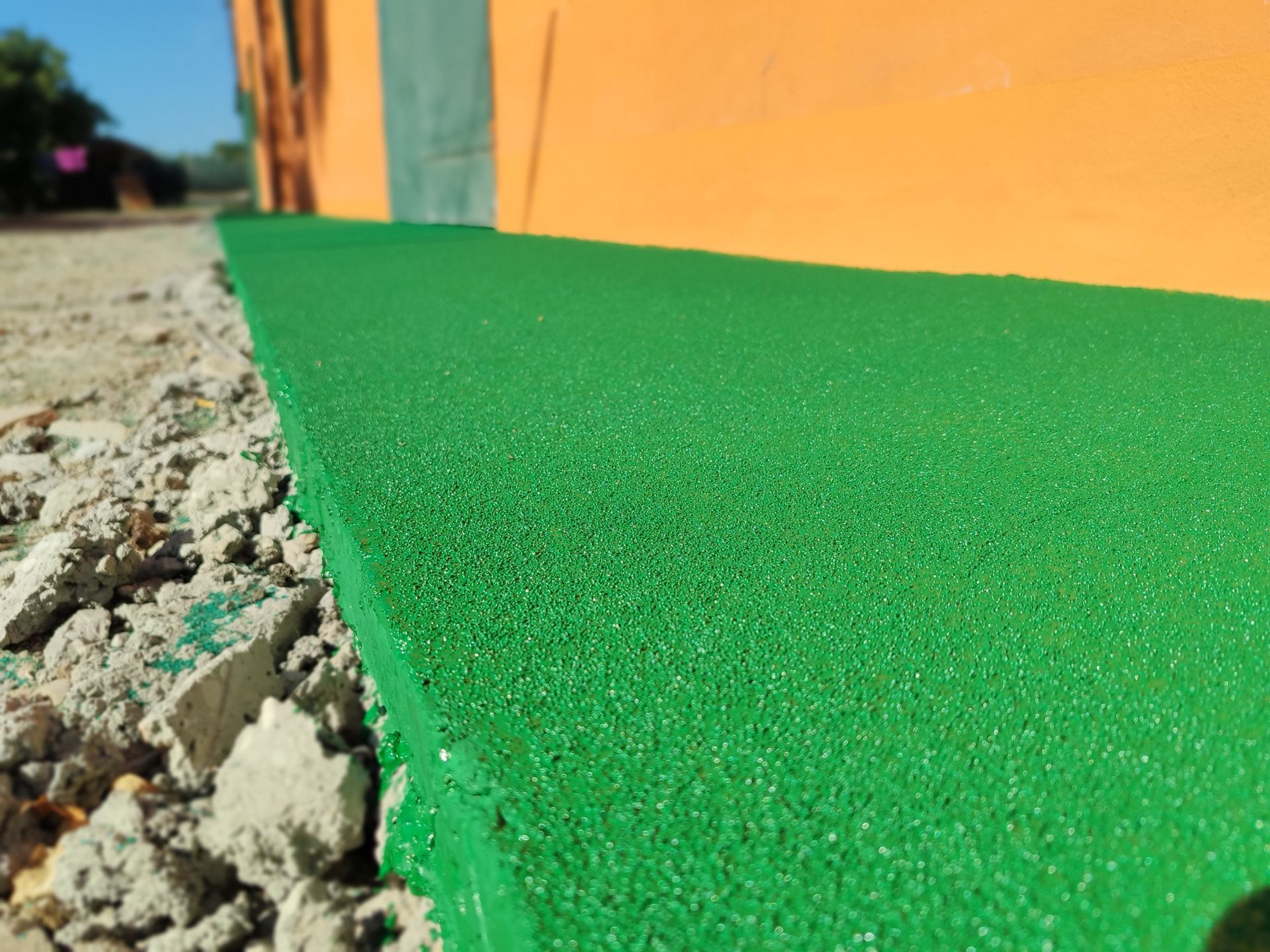 Passerella in gomma verde installata accanto a un edificio.