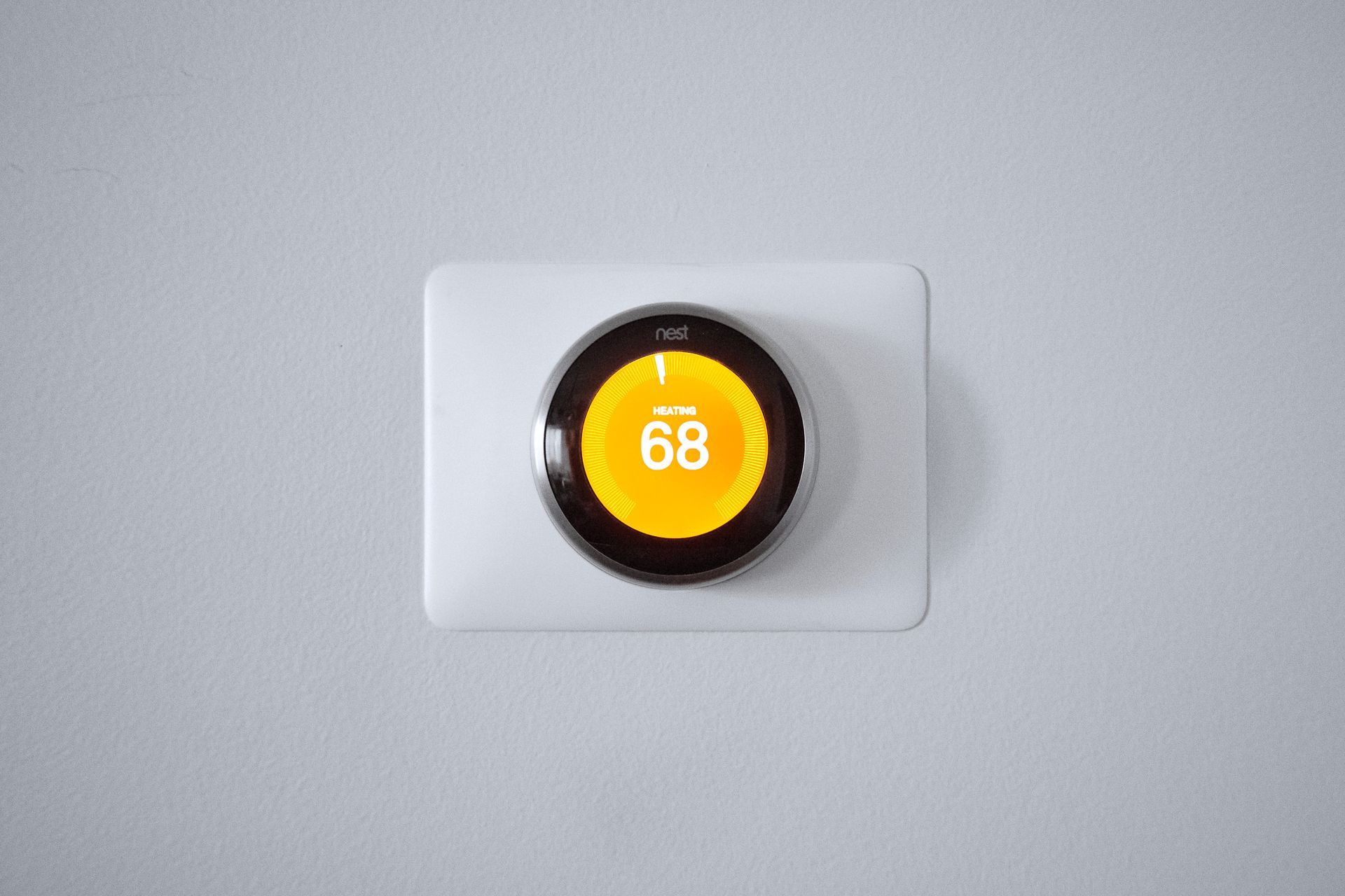 Multi-story apartment building with blue and gray siding, trees, and a walkway on a sunny day.