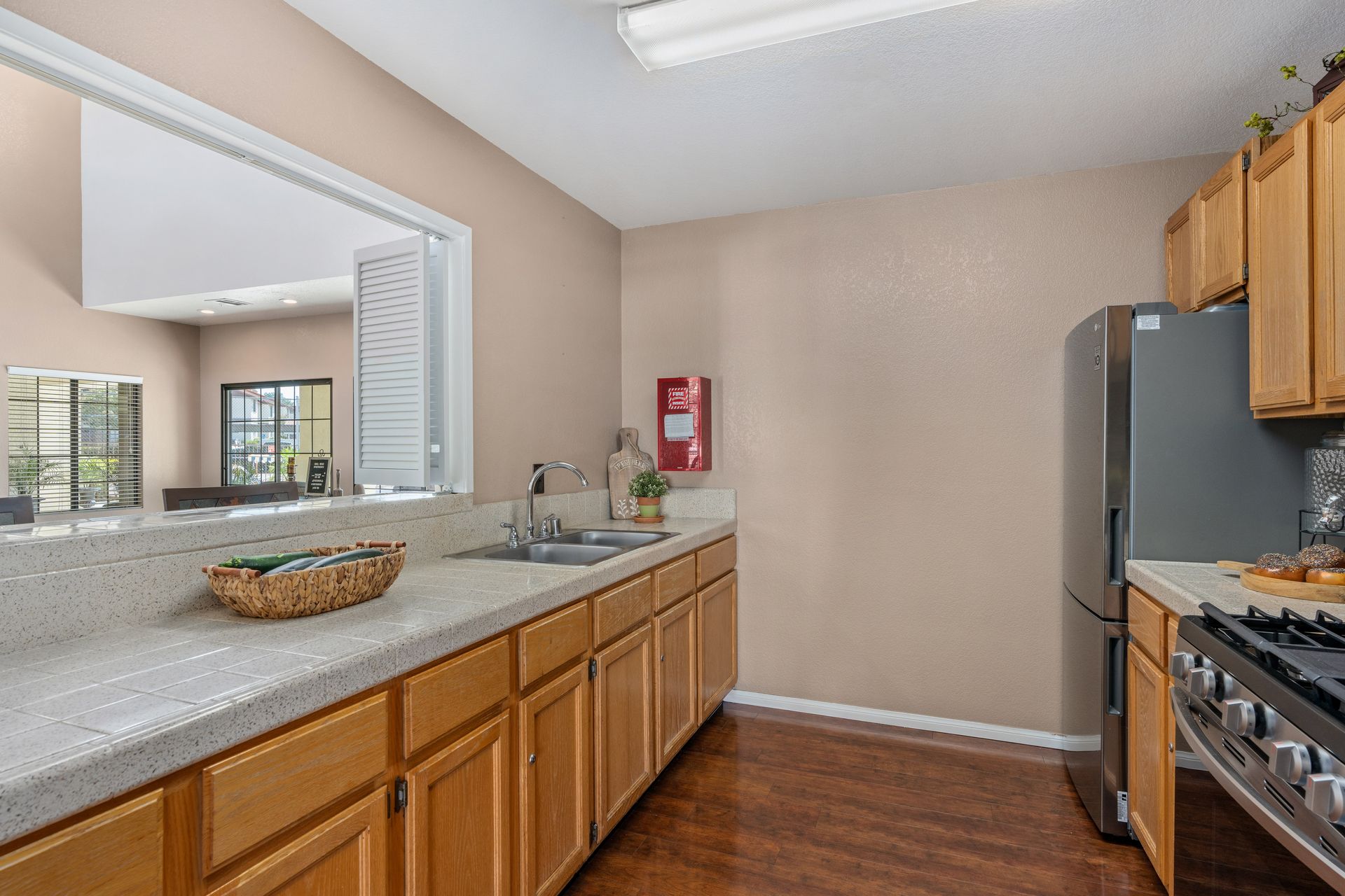 Kitchen with light wood cabinets, beige walls, and stainless steel appliances.