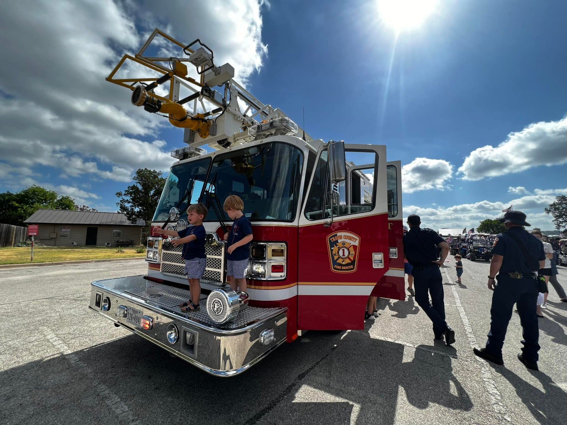 Two young boys are standing in front of a fire truck.