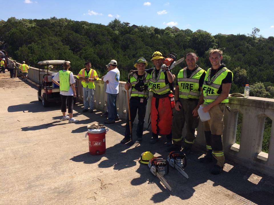 A group of firefighters are standing on a bridge.