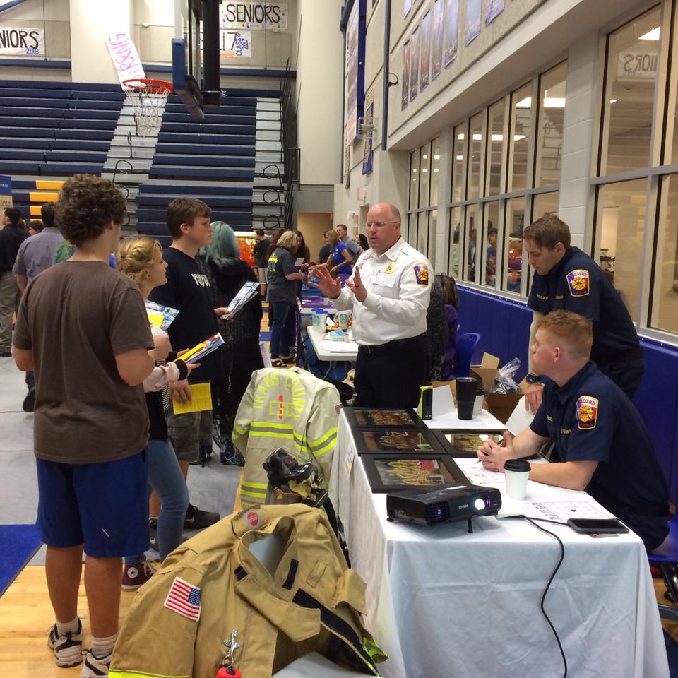 A group of people standing around a table with a sign that says seniors on it