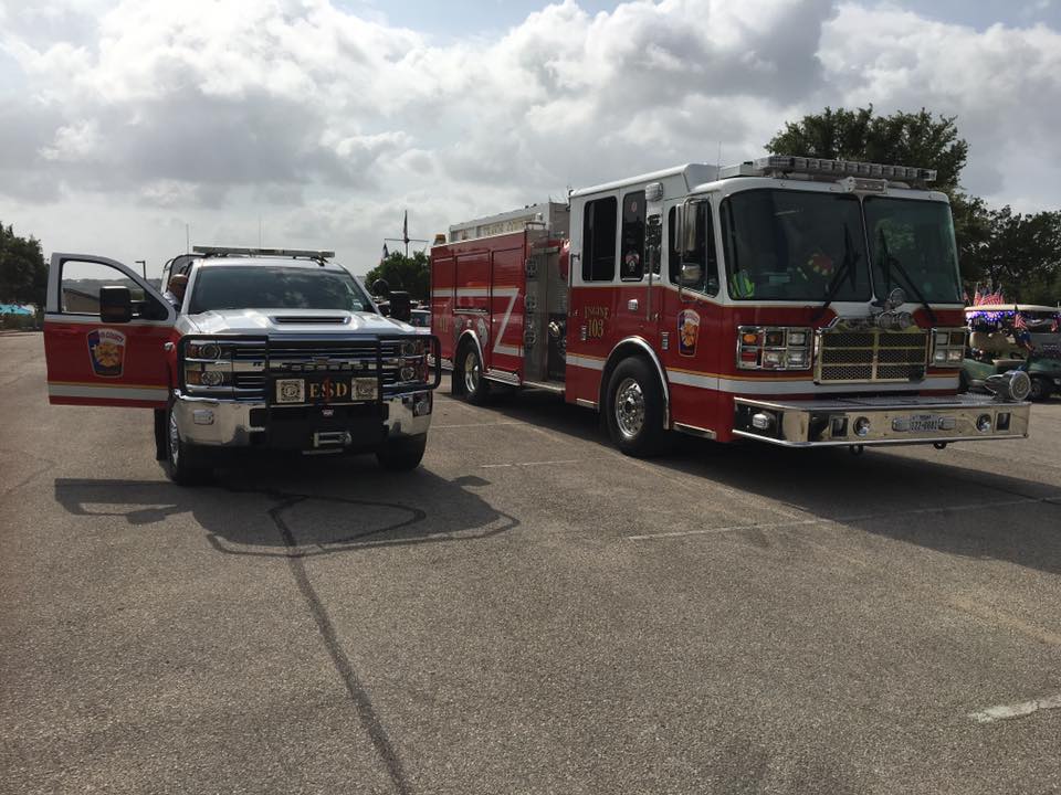 Two fire trucks are parked next to each other in a parking lot.