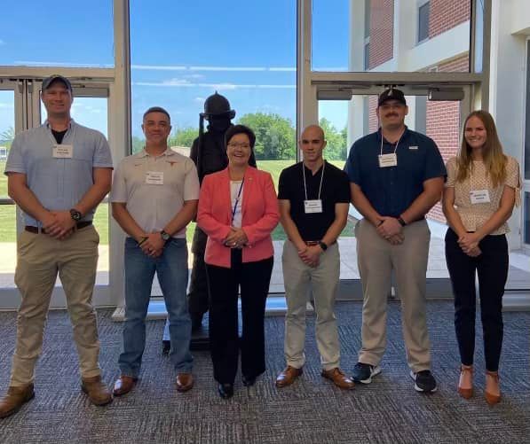 A group of people posing for a picture in front of a window