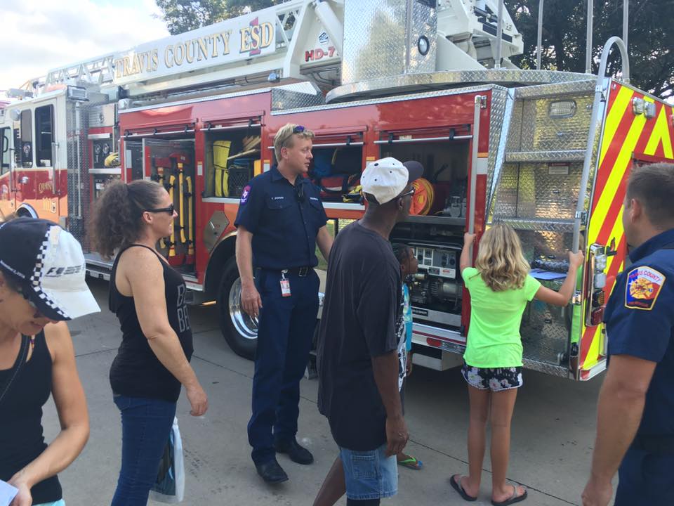 A group of people are standing in front of a fire truck.