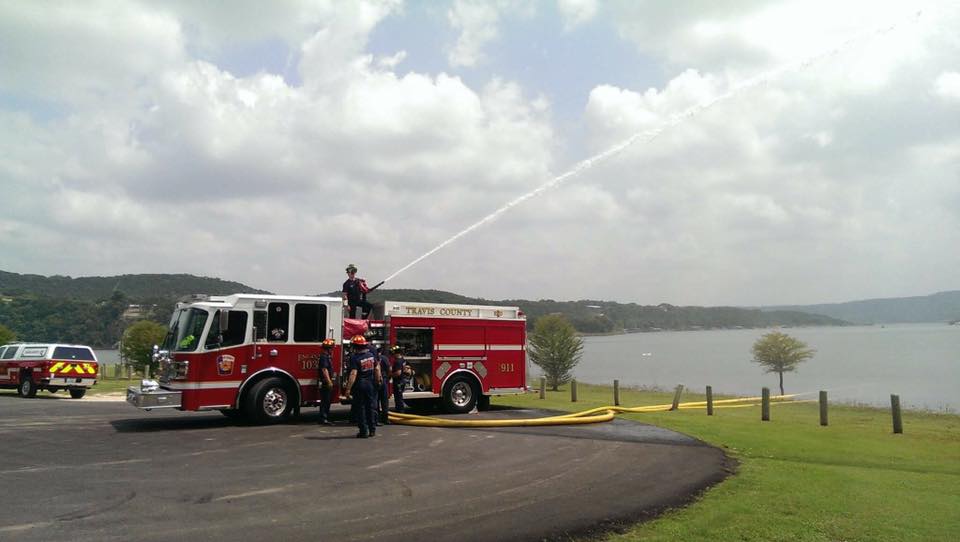 A fire truck is spraying water on a lake