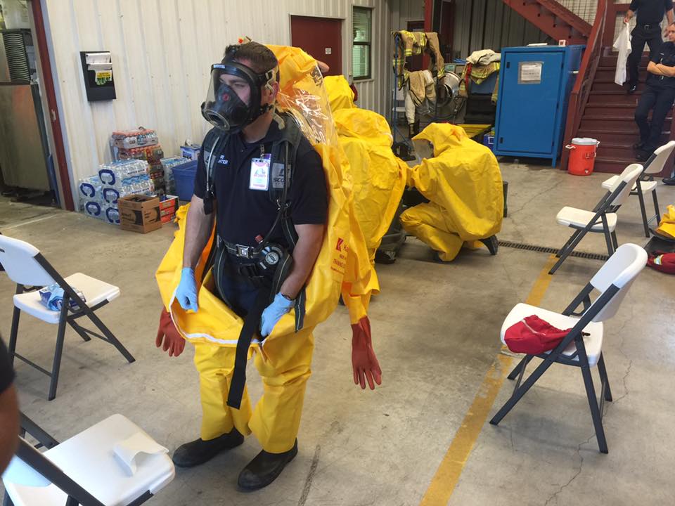A man wearing a gas mask and a yellow protective suit