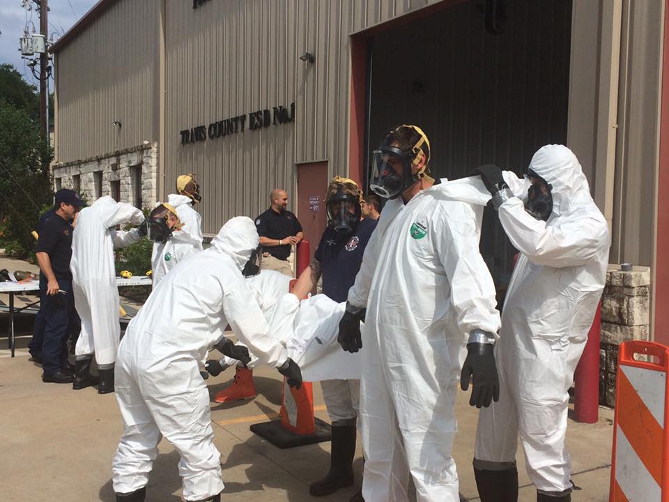 A group of people in protective suits outside of a building