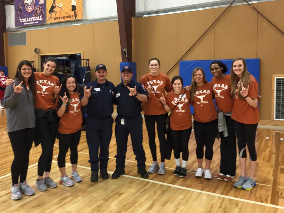 A group of people are posing for a picture in a gym.