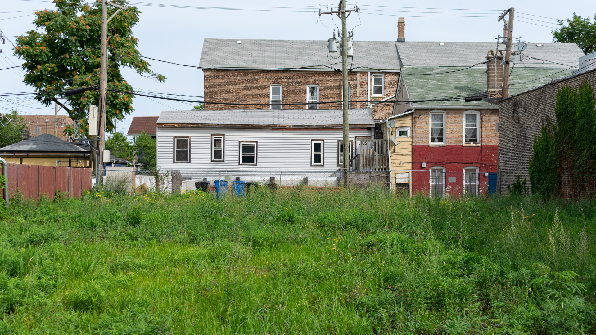 A row of houses are sitting next to each other in a grassy field.