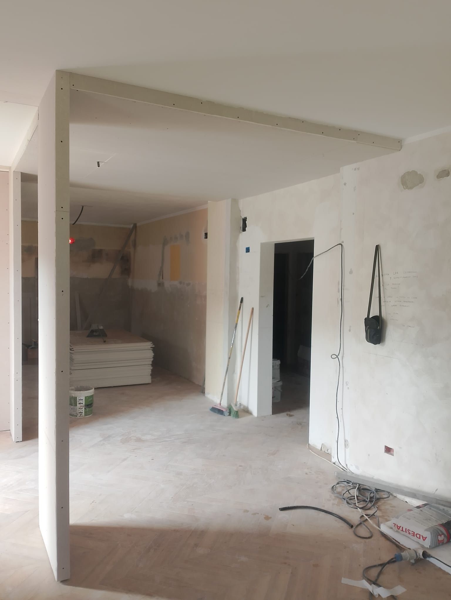 Una stanza in fase di ristrutturazione con un sacco di scatole sul pavimento.