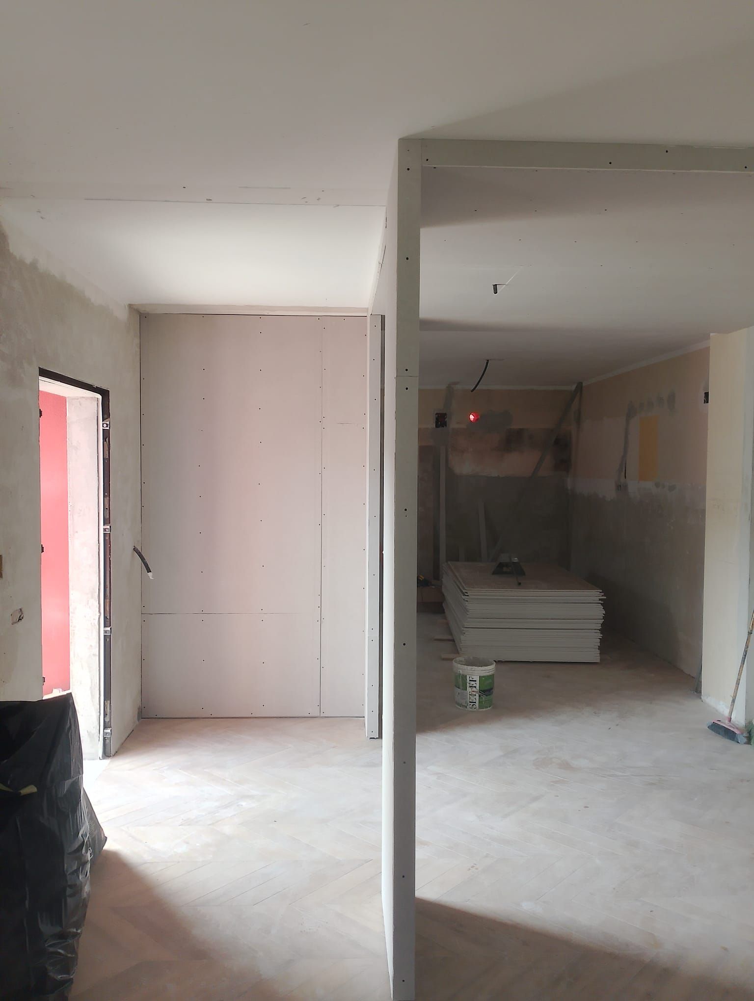 Una stanza vuota con una porta rossa e pareti bianche