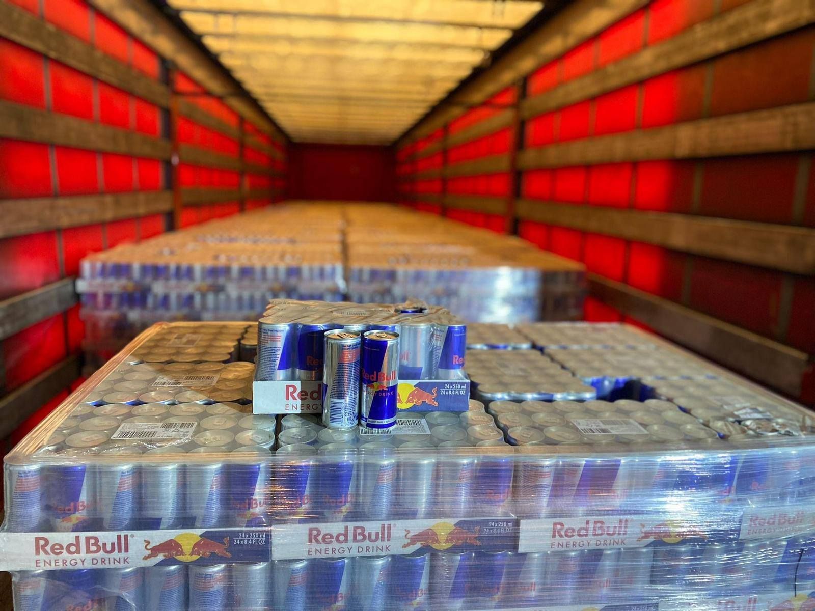 Inside a truck trailer, stacked pallets of Red Bull cans are ready for delivery.