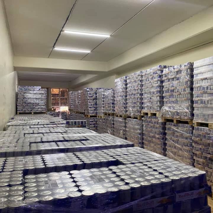 Warehouse interior with many pallets of canned goods stacked high.
