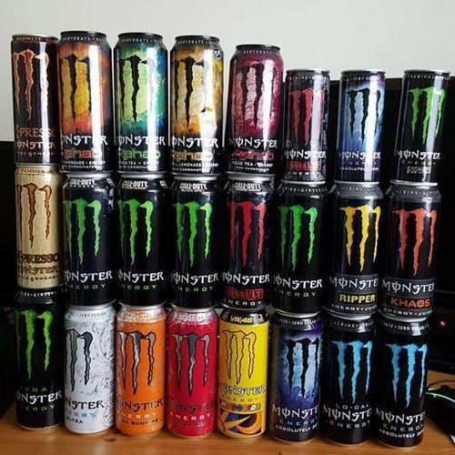 A collection of colorful Monster energy drink cans stacked vertically.