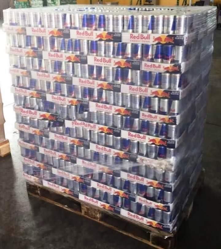 Pallet of Red Bull energy drink cans wrapped in clear plastic.