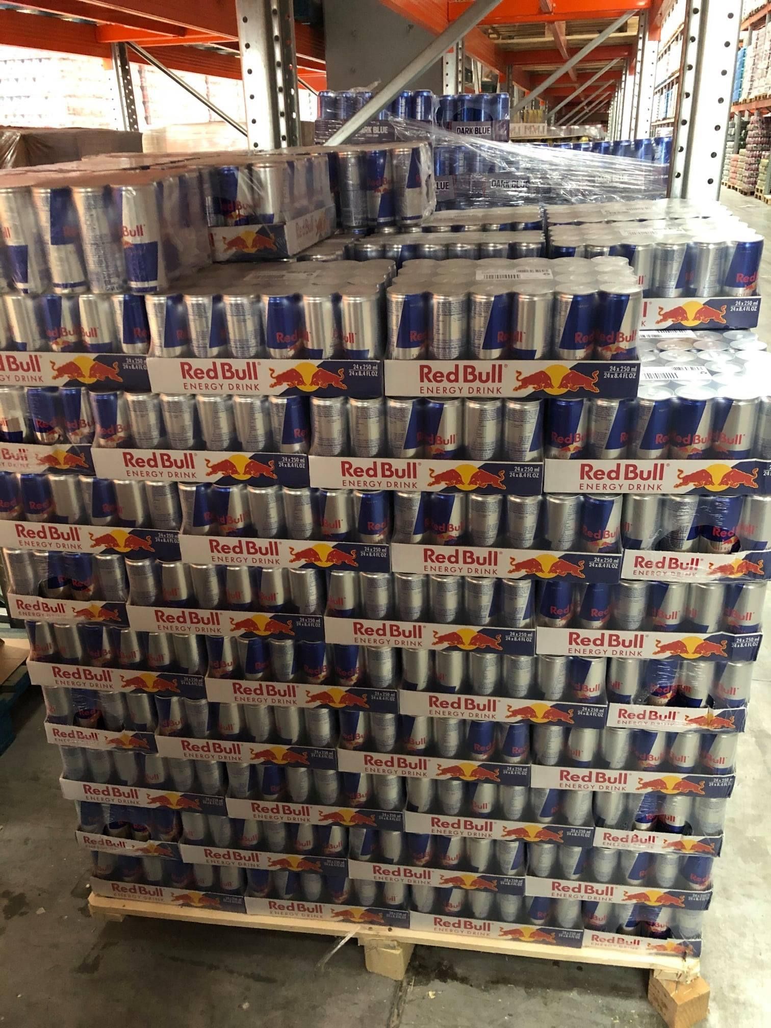 Pallet stacked with many Red Bull energy drink cases in a warehouse.