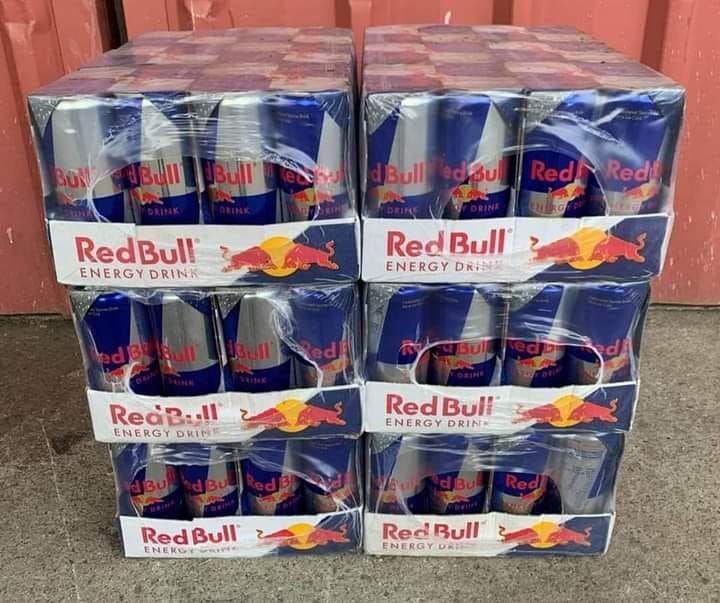 Four stacks of Red Bull energy drink cases, wrapped in clear plastic.
