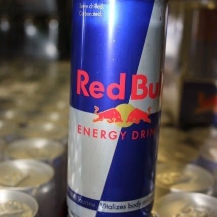 Red Bull energy drink can, blue and silver, in a group of cans.
