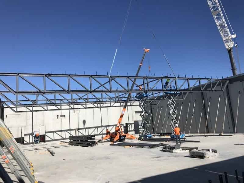 A Group Of Men Standing On Top Of A Building Under Construction | Canberra ACT | Baxter Engineering