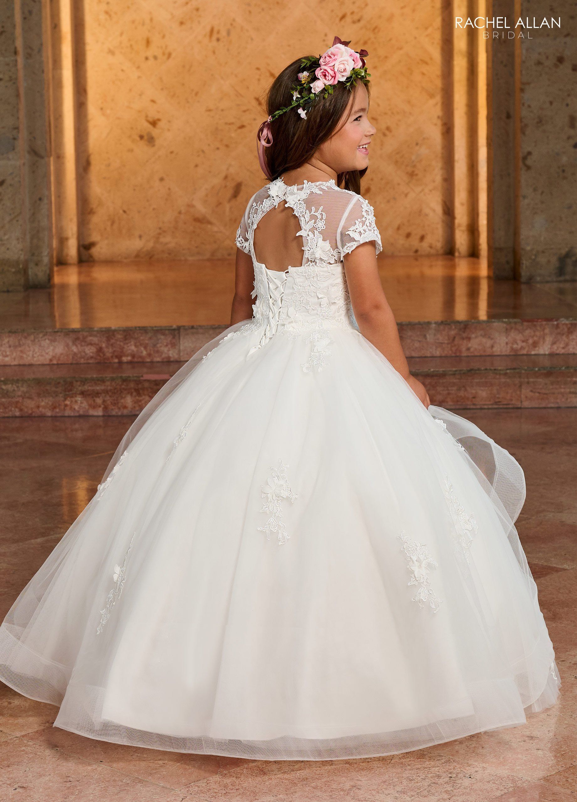 A  flower girl in a white dress with a flower in her hair