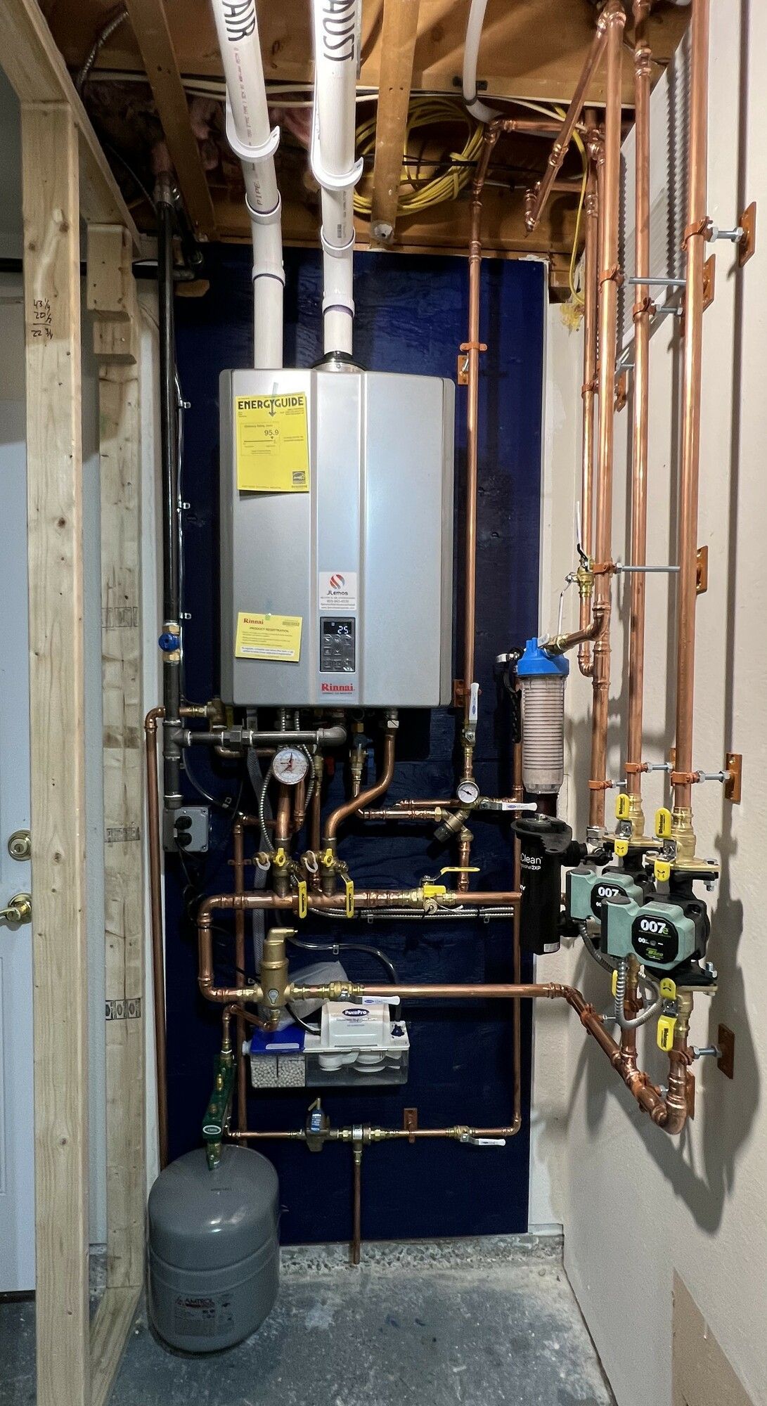 a room with a water heater and copper pipes .