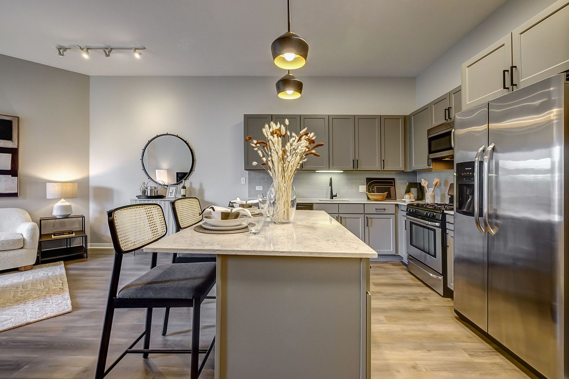 A kitchen with stainless steel appliances and a large island in the middle.