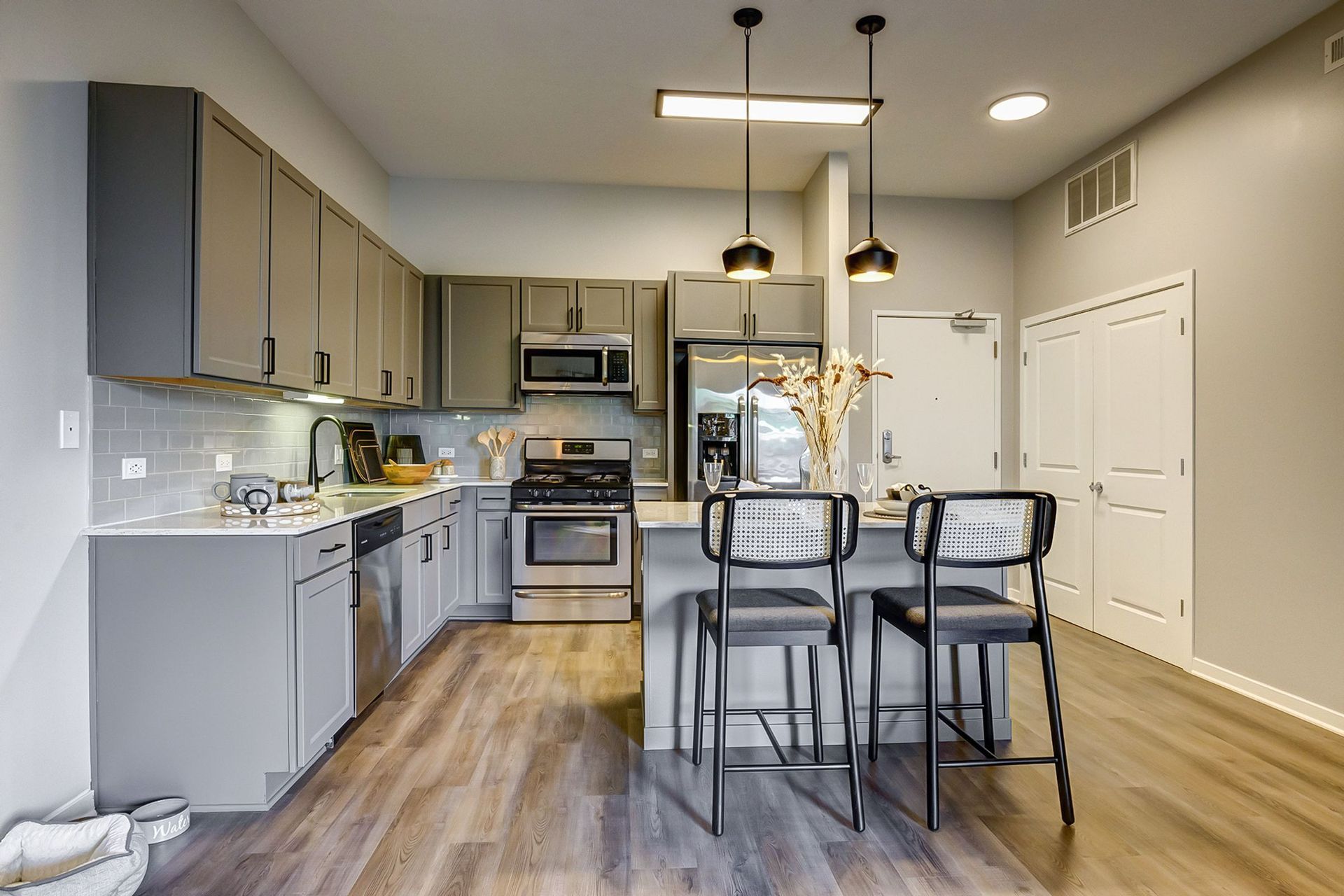 A kitchen with stainless steel appliances and wooden floors.