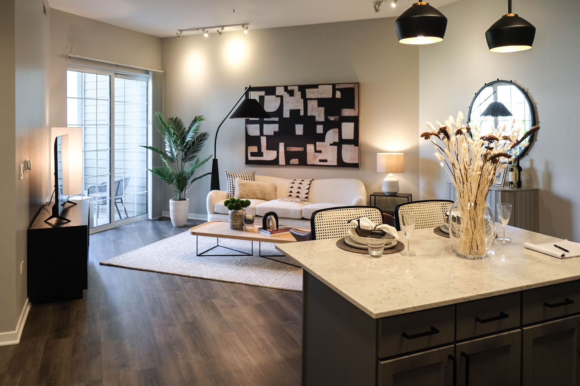 A living room with a couch , coffee table , and sliding glass doors.